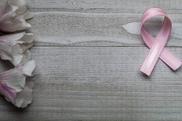 Pink Ribbon on weathered gray board for cancer awareness, women's health, breast cancer.  Copy...