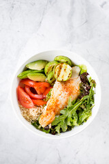 Healthy Salad Fish Bowl. Zander, vegetables, green leaves, avocado, tomato and brown rice in bowl