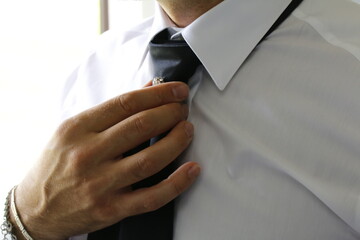 uomo che sistema la cravatta