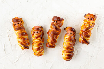 Scary sausage mummies in dough for kids party. Funny crazy Halloween food for children.