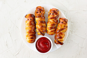Scary sausage mummies in dough for kids party. Funny crazy Halloween food for children.