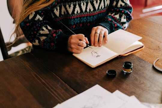 young woman sketching with ink