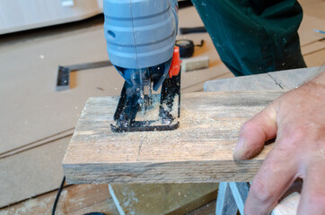 
Man sawing a board with fret-saw.
Manufacturing of wood products