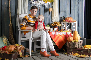 mom and daughter sit on a chair in halloween decorations