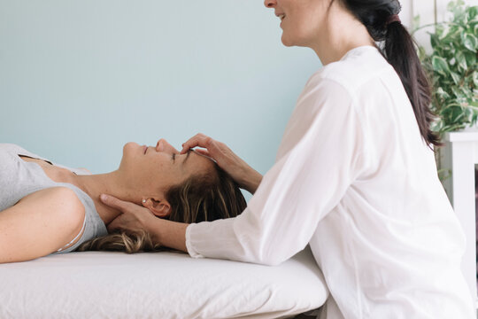 Professional Osteopath Working With Relaxed Caucasian Woman