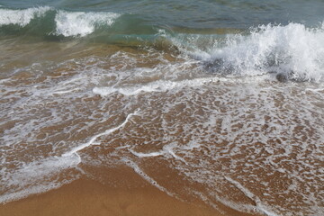 onde che si infrangono su una spiaggia di sabbia