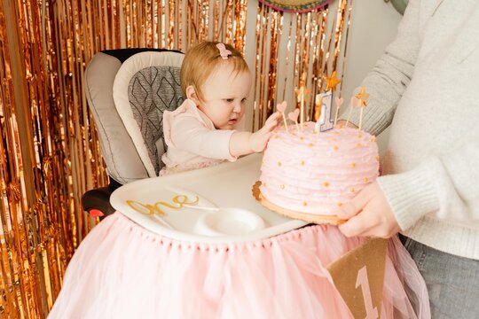 dad giving baby girl her birthday cake