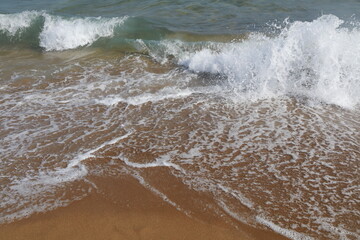 onde che si infrangono su una spiaggia di sabbia