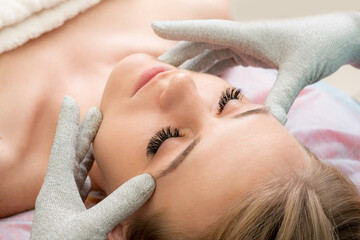 Woman getting lifting therapy massage in a beauty SPA salon.