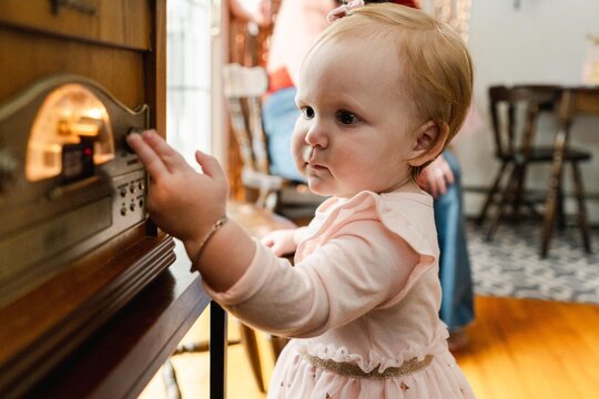 baby girl turning the volume up on the radio