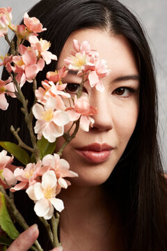 Mixed Race Asian Woman Posing With Flowers