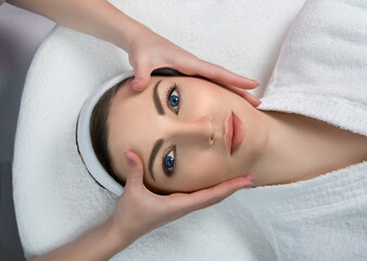 young relaxing beautiful woman having facial massage