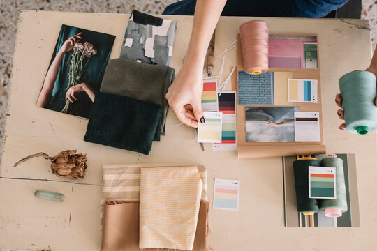 Hands Of Young Woman Choosing Fabric For Moodboard