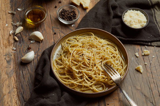 aglio e olio pasta served on a wooden table.