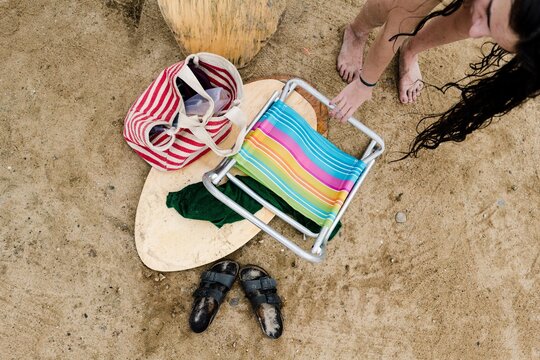 teen girl putting down beach stuff