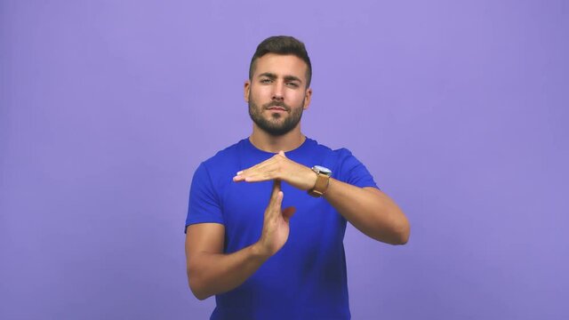 Young caucasian handsome man tired and bored, doing a timeout gesture, needs to stop because of work stress, time concept