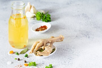 Homemade chicken (bone) broth/bouillon with vegetables, spices and herbs in a bowl (cup) on a light background. Natural collagen of animal origin. Liquid broth from meat, fish, vegetables.
