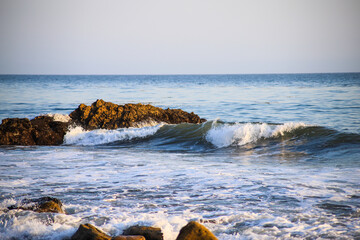 ocean waves rolling in at the beach crashing into the rocks at El Matador beach in Malibu California