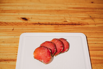 lomo cocido embuchado en rodajas en tabla