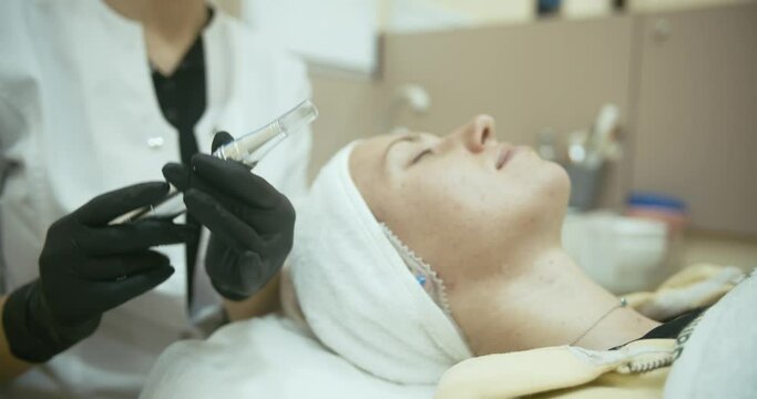 young woman with problem skin receiving mesotherapy facial treatment in beauty clinic