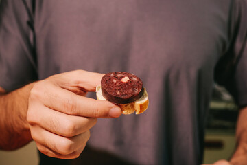 blood sausage slicer over toasted bread in hand