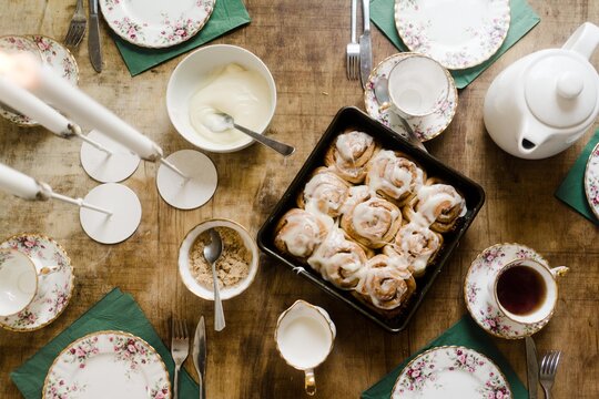 breakfast table with cinnamon rolls and a vintage tea set