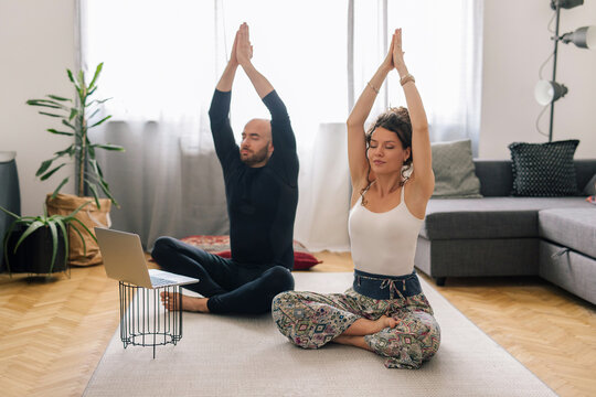 Couple doing yoga at home