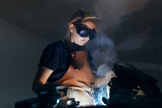 Female artist welding a sculpture.