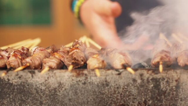 Arrosticini on the grill cooked while turning. Adult sheep meat, typical of Abruzzo region, Italy