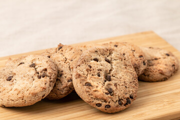 Tasty chocolate cookies on wooden cutting board