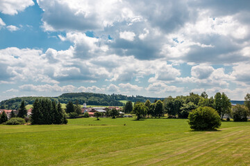 Little village in the middle of the german countryside with hills, forests, fields and meadows