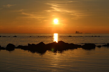 panorama con sole che sta per tramontare in mezzo al mare