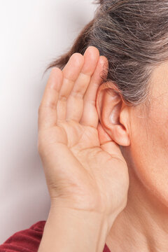 The woman is trying to hear. Hearing problem.