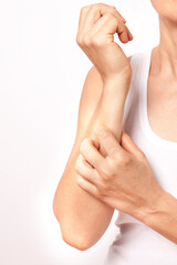 The woman is scratching her arm.