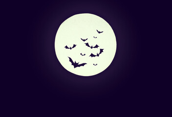 Dark Halloween background.Silhouettes of bats against a round full moon.copy space.creepy mood