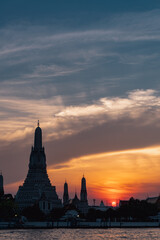 Fototapeta na wymiar Templo do Amanhecer Wat Arun, em Bangkkok, Tailândia, com belo por-do-sol ao fundo. Céu colorido.