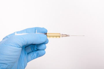 The doctor is holding a syringe in her hand.