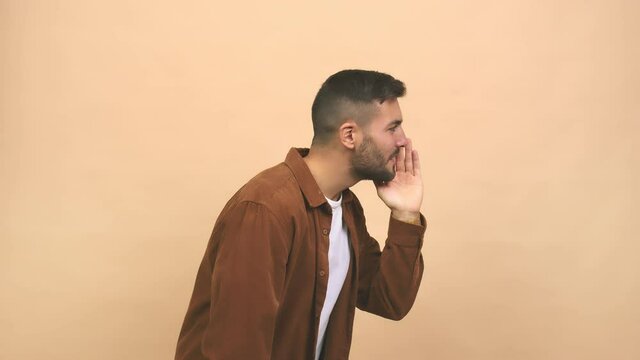 Young caucasian handsome man whispering gossip undertone, trying not to be heard