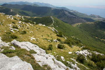 Fototapeta na wymiar Hiking Velebit mountain in Croatia in summer, Velebit peaks Visibaba Kiza, Bacic kuk mountain rocks at Dabarski kukovi