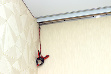 Stretching ceiling installation. Close-up of a hanging clamp using for holding a stretch ceiling canvas