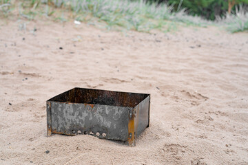Brazier on wet sand and grass