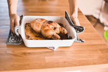attractive nerd guy with glasses in stylish kitchen follows a recipe on the phone prepares chicken