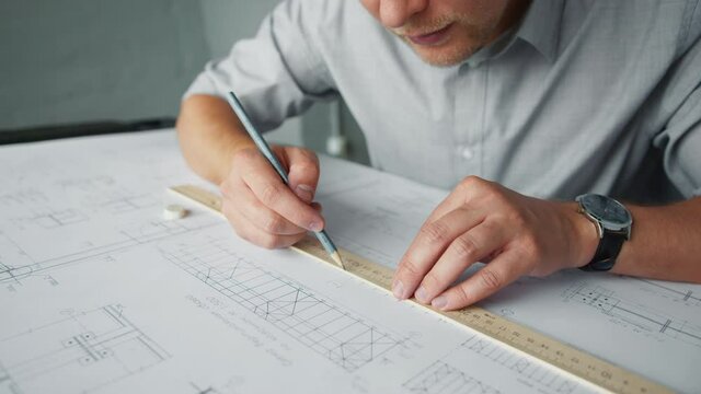 Young man with construction plan in office