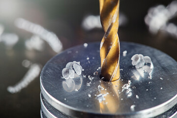 metal drill bit make holes in steel billet on industrial drilling machine. Metal work industry....