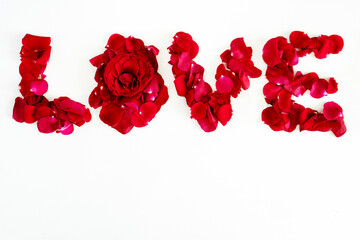 Valentine's day concept. The word Love is lined with rose petals on a white background, top view, flat lay