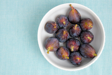 Figs fruits in a bowl, top view.