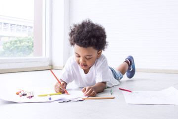 Little african boy is drawing and painting