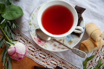 A cup of tea and cookies on a lace napkin