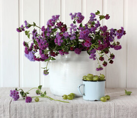 purple ageratum and green gooseberry. still life.