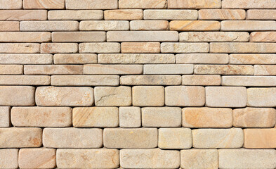 The wall is lined with hewn rounded yellow sandstone stone.